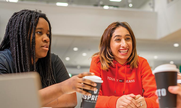 Two female students sat down with a coffee talking